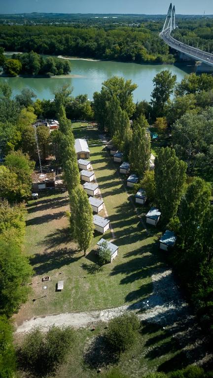 an aerial view of a row of tents next to a river at Gedeon Garden in Budakalász