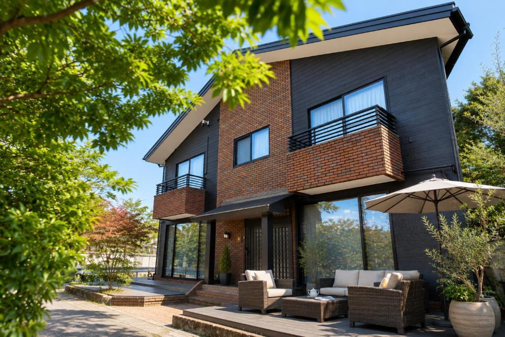 a house with a patio in front of it at 別荘 1日1組貸切 芦ノ湖徒歩1分 最大16名 BBQ設備レンタルOk 無料駐車場 in Hakone