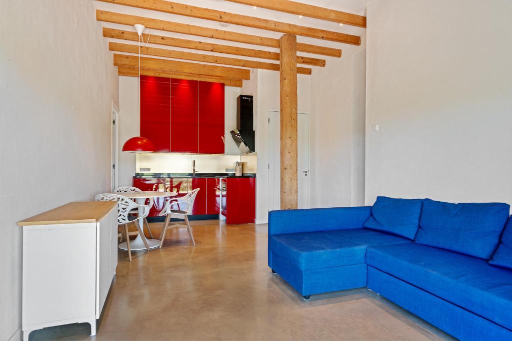 a living room with a blue couch and red cabinets at HollyWad in Holwerd