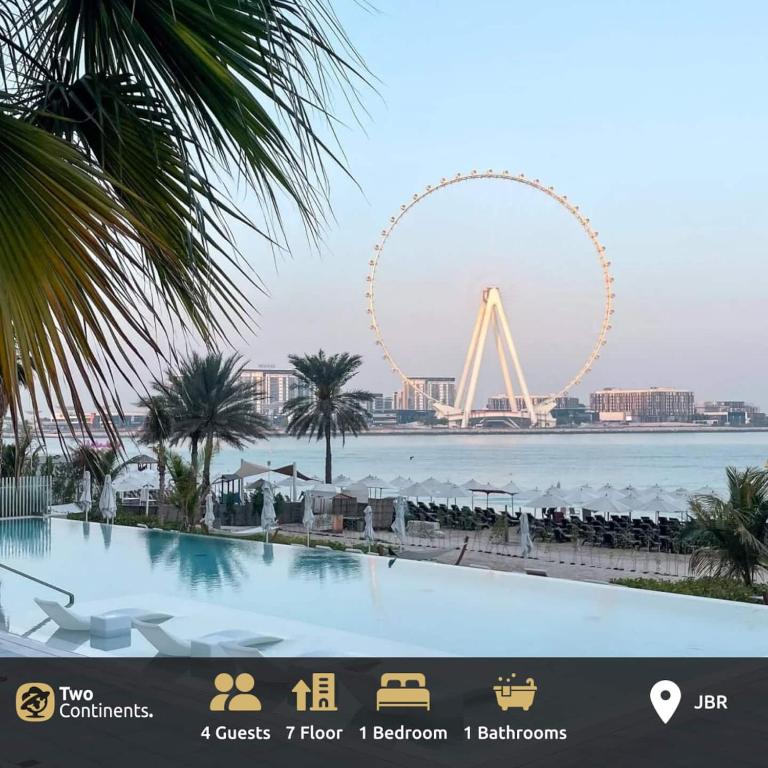 a large swimming pool with a ferris wheel in the background at La Vie on JBR in Dubai