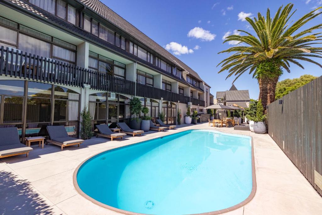 a swimming pool in front of a building at Auckland Rose Park Hotel in Auckland