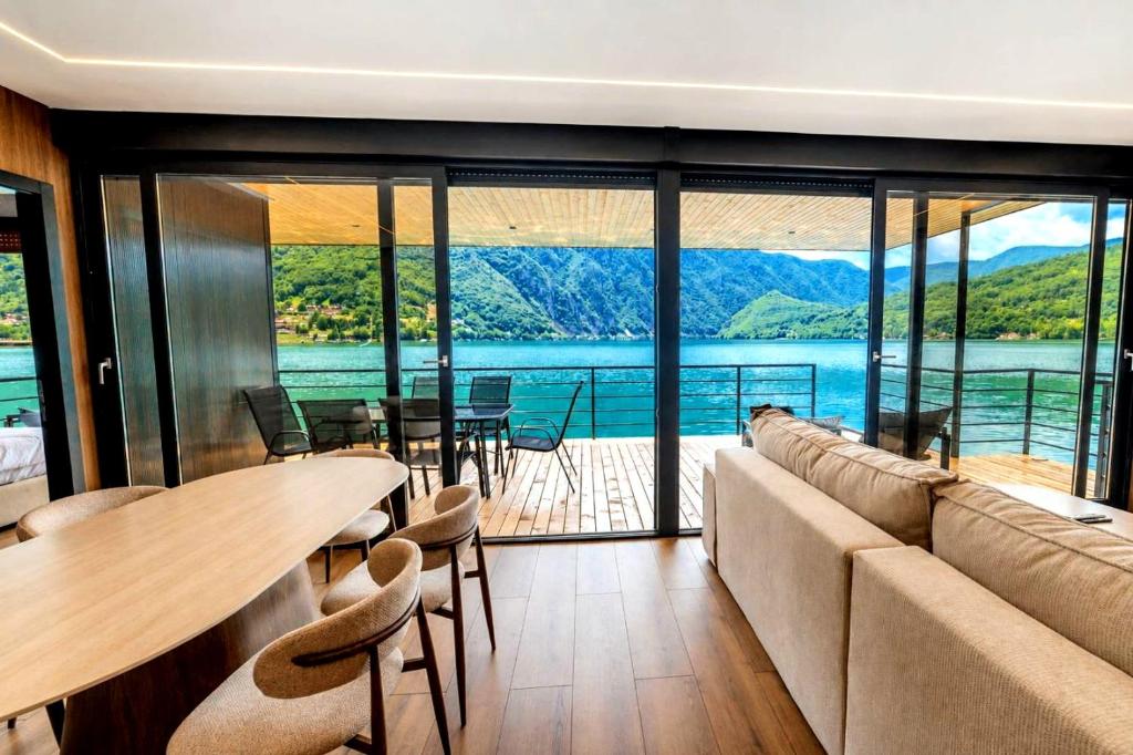 a living room with a couch and a table and chairs at Perućac Lake Residence in Miličevići