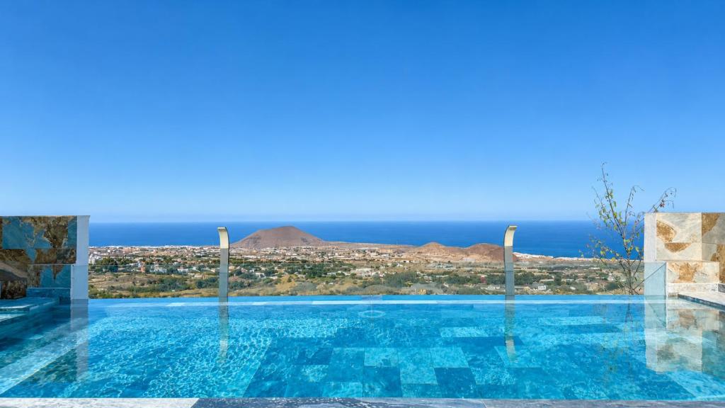 a large swimming pool with a view of the ocean at JVG VILLAS - Villa Valeria in Güimar