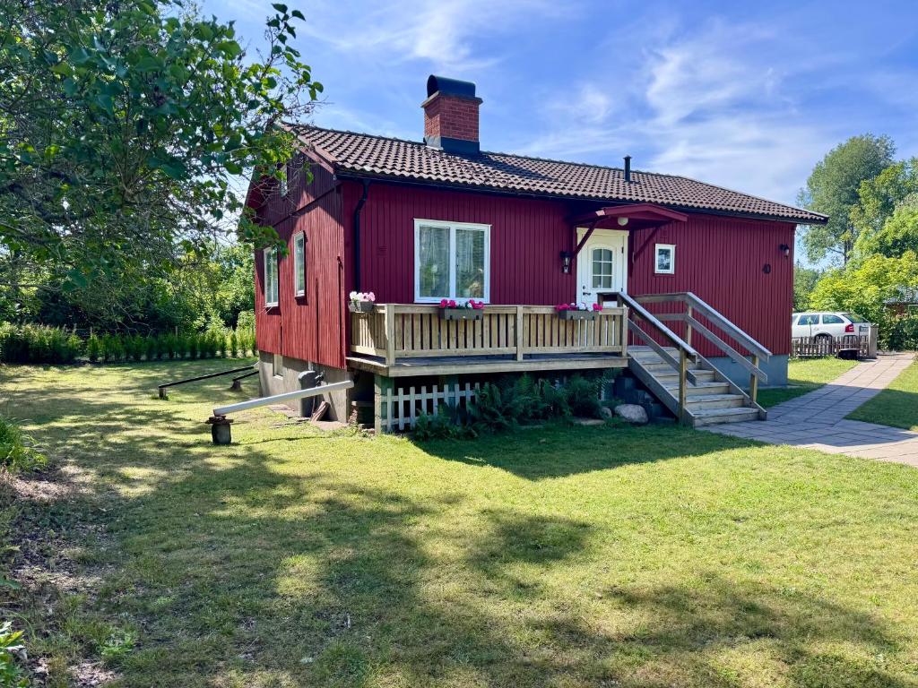 a red house with a porch and a deck at KalmarStay in Blomstermåla