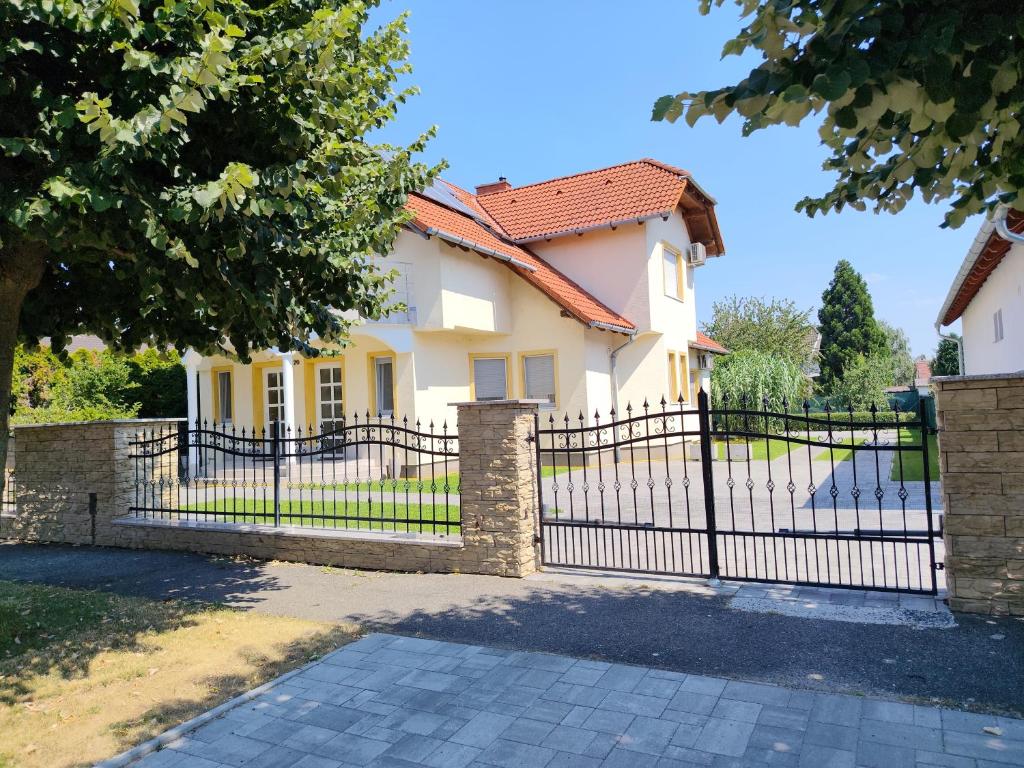 a black fence in front of a house at Abigel Thermal Apartman in Bük