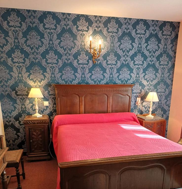 a bedroom with a red bed with blue wallpaper at Le Commerce in Bulgnéville