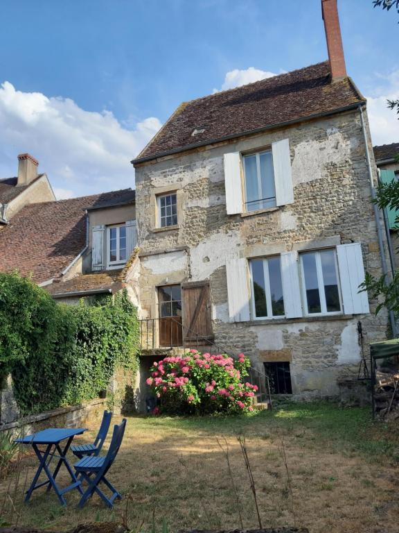 a house with a table and chairs in front of it at Maison Corbigny in Corbigny
