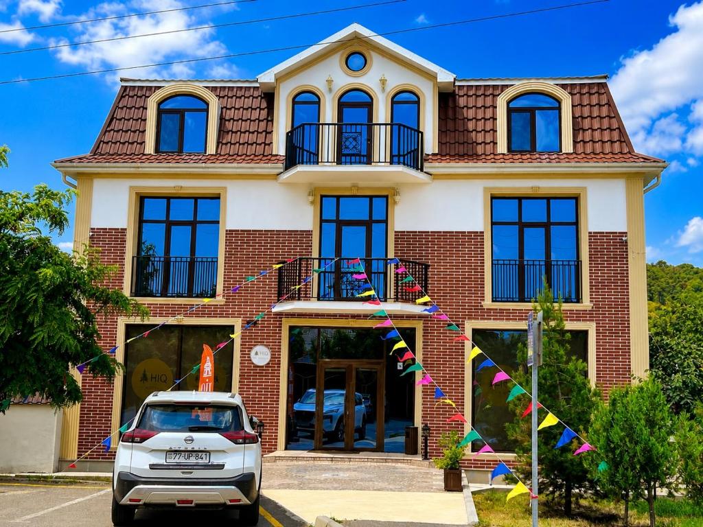 a house with a car parked in front of it at HIQ Hotel Home Inn Qusar in Qusar