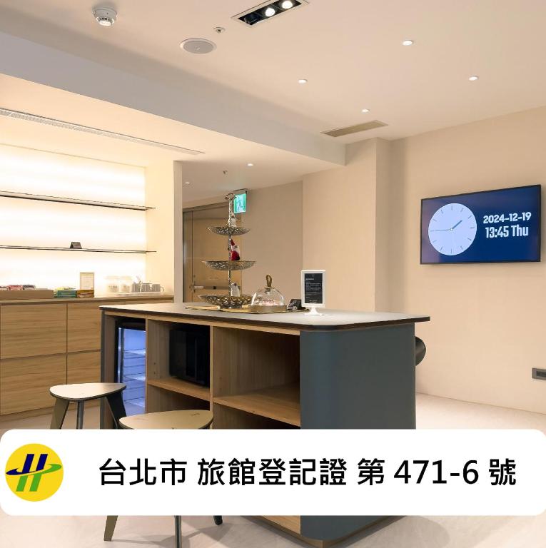 a kitchen with a counter and a tv on the wall at Lumos Inn 拾光行旅 in Taipei