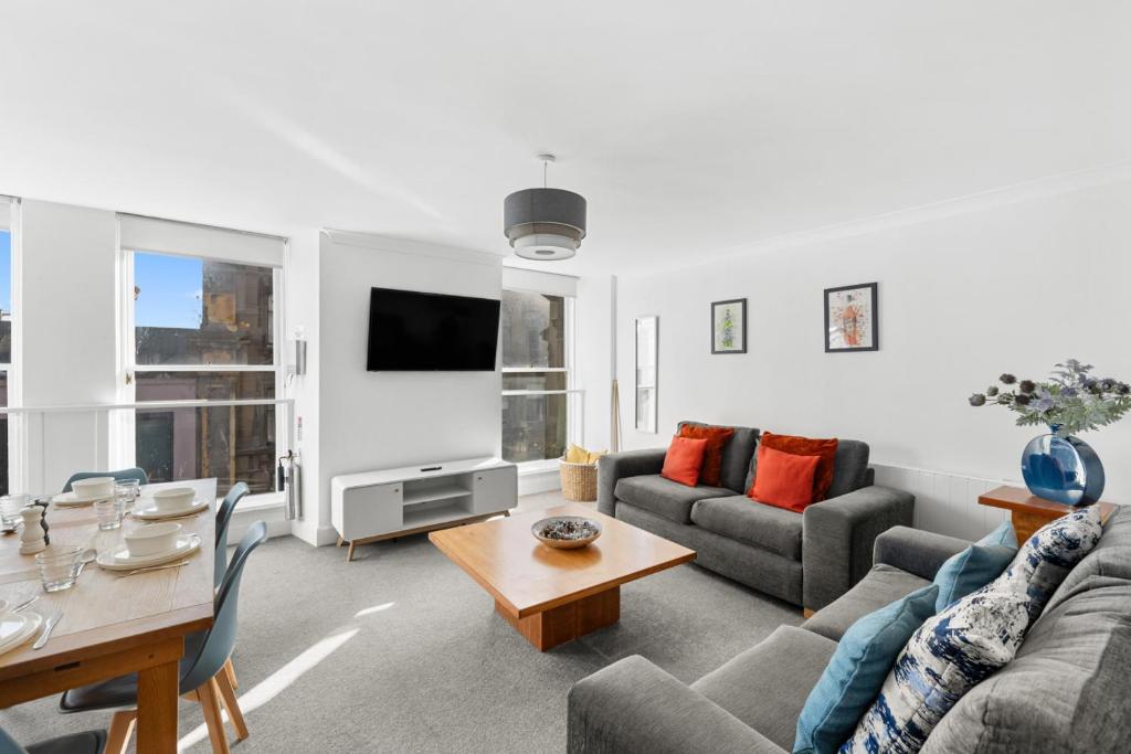 a living room with a couch and a table at Henry's Apartment on Commercial Street in Dundee