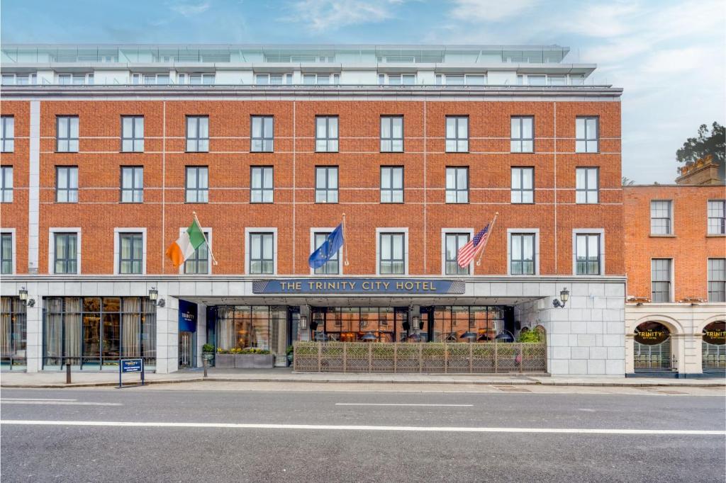 a large red brick building with flags on it at The Trinity City Hotel in Dublin