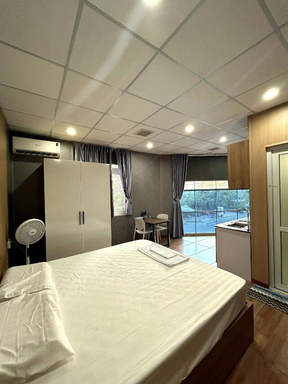 a bedroom with a large bed and a kitchen at Linh's House in Danang