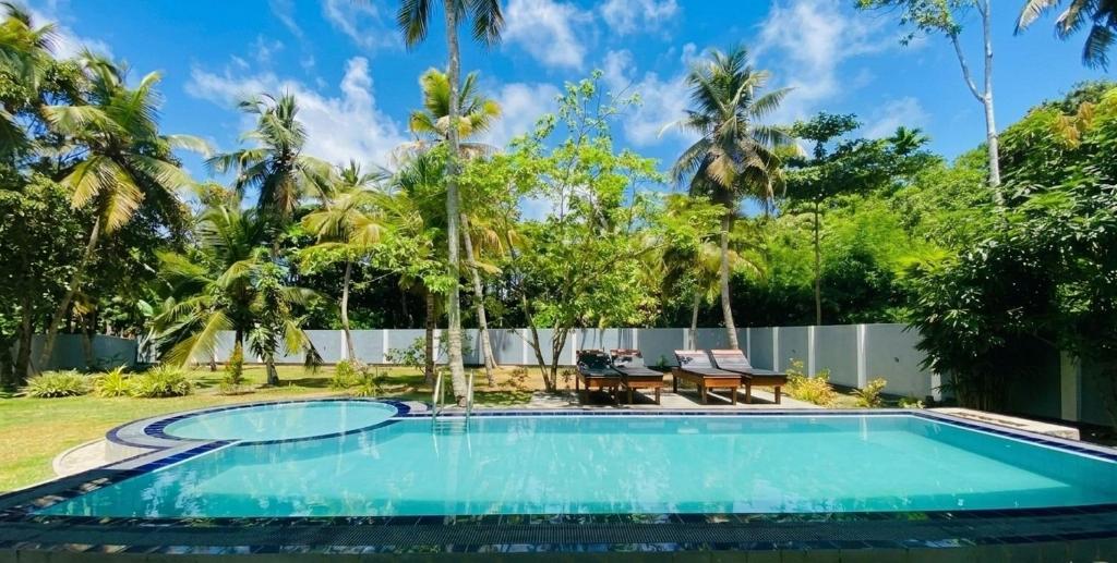 a swimming pool in the backyard of a villa at sunset villa in Hikkaduwa