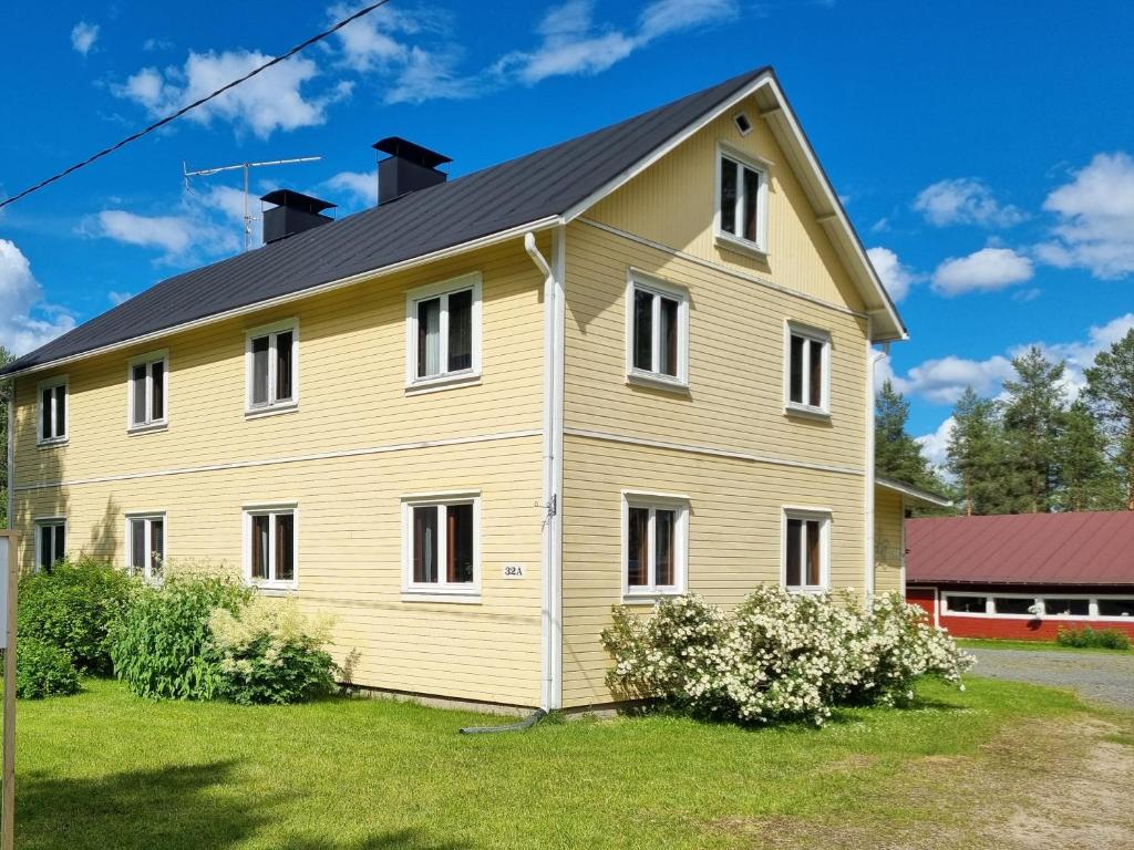 a yellow house with a black roof at Mattilan talo b&b in Impiö