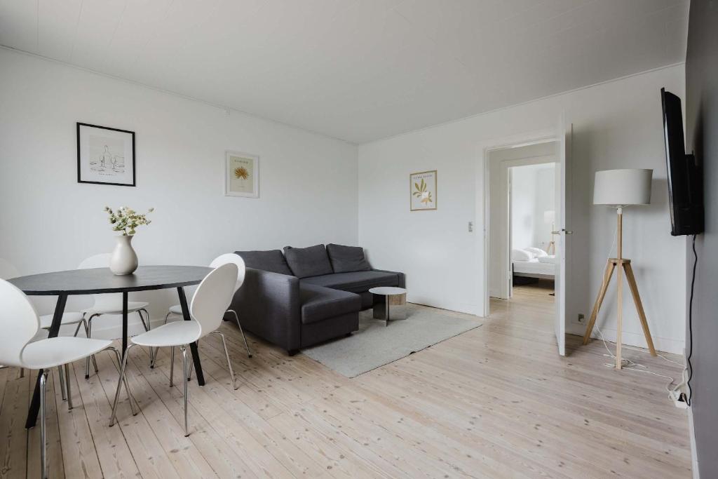 a living room with a couch and a table and chairs at Lovely cozy apartment in Søborg