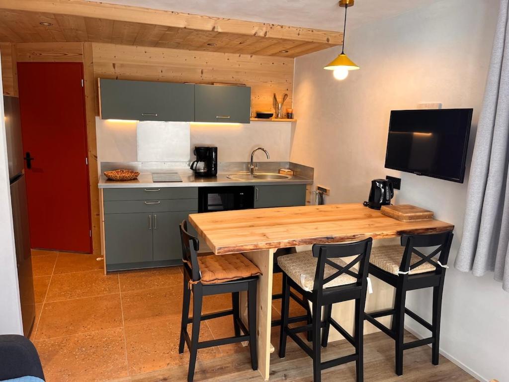 a kitchen with a wooden table and some chairs at Le Plainpalais - 4pers - Balcon vue Montagnes in Les Déserts