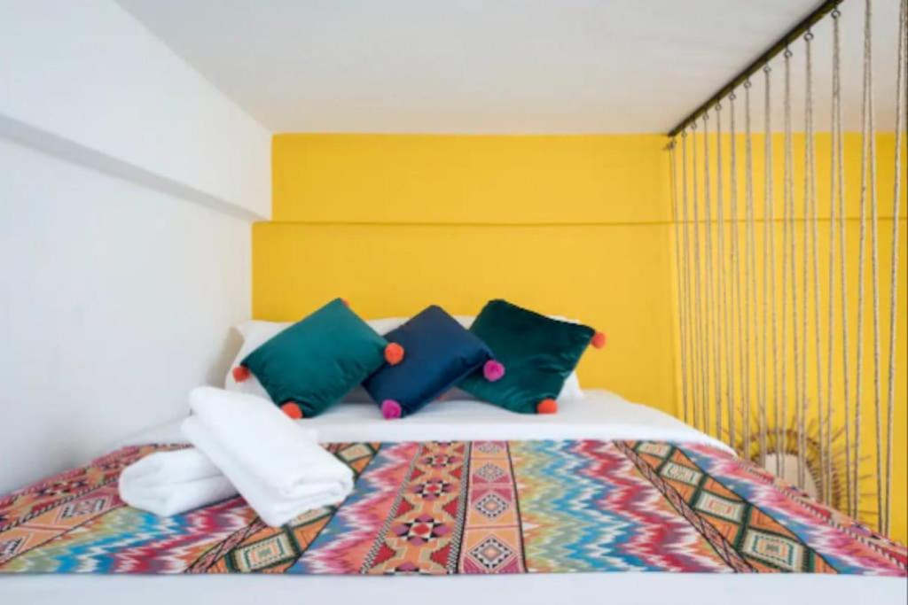 a bedroom with a bed with colorful pillows at Boho Studios in Mar Mikhael in Beirut