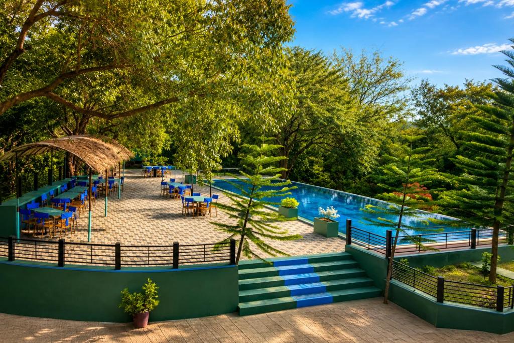 a resort with a pool and tables and chairs at Mounts Edge Regency in Mahiyangana
