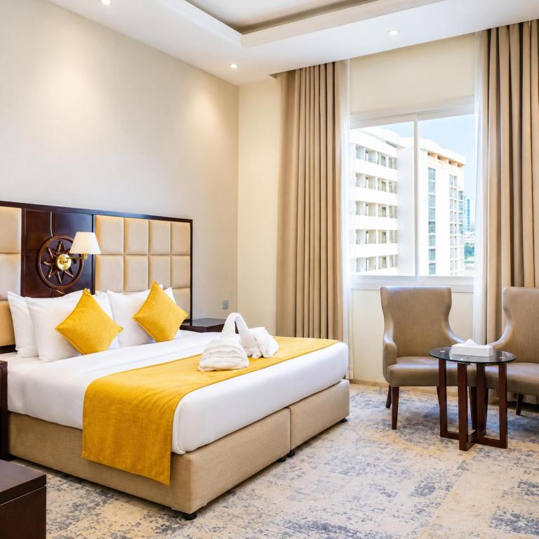a hotel room with a bed and a desk and chair at Hotel Meenakachi Resort in Brahmapur