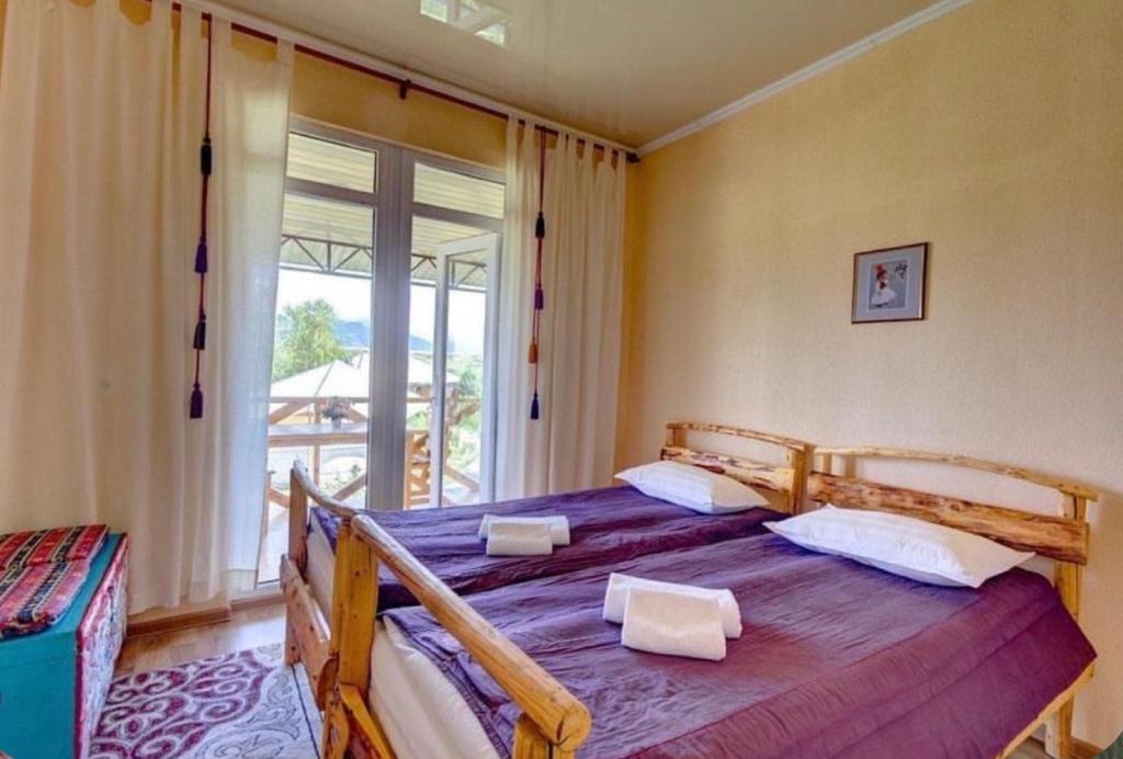a bedroom with two beds and a large window at Reina-Kench in Kunduy