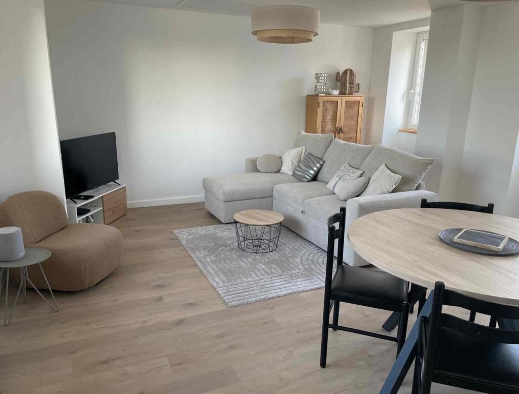 a living room with a couch and a table at appartement la pause coté mer in Santec