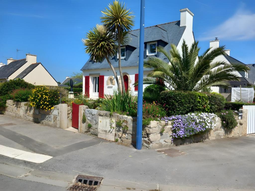 a house with palm trees and flowers in front of a street at Bénodet Chambre D'hôtes Les Sauges in Bénodet