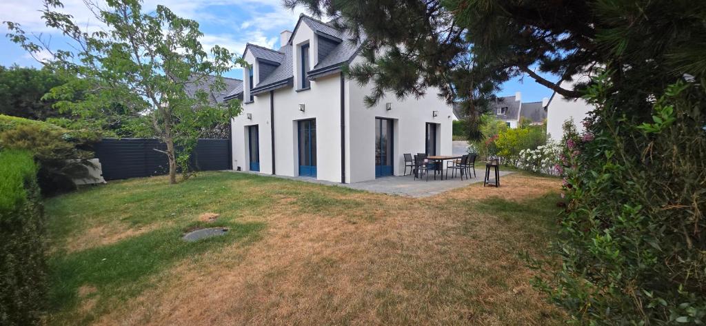 a white house with a table in a yard at Ker Giz 14 in Arzon