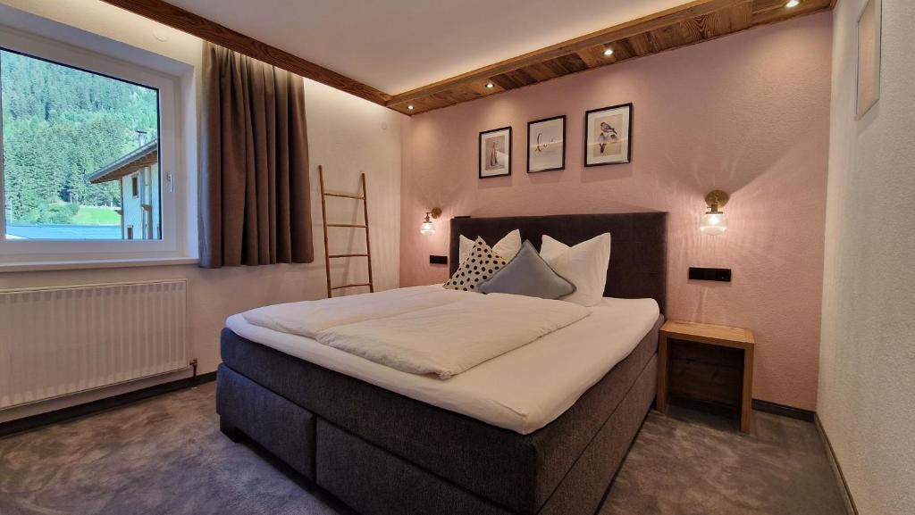a bedroom with a large bed and a window at Chasa Patria Apartments in Ischgl