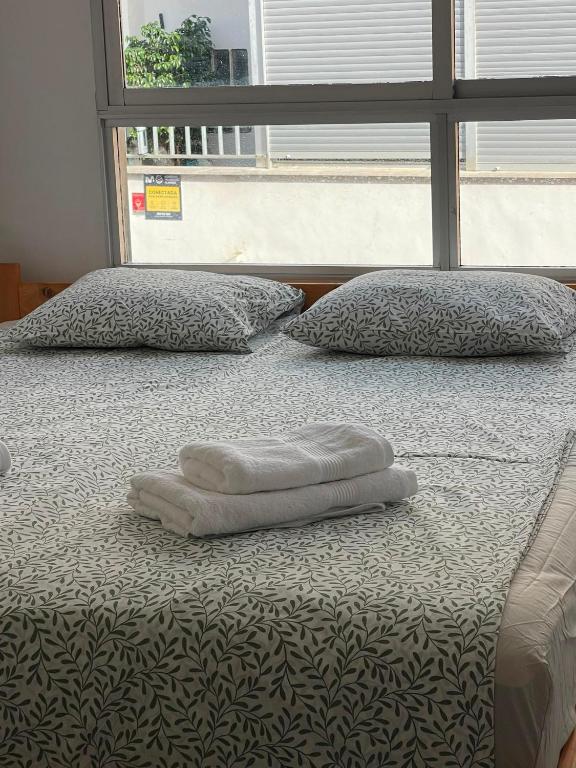 a bed with two pillows on it with a window at Simat Malina 2 in Simat de Valldigna