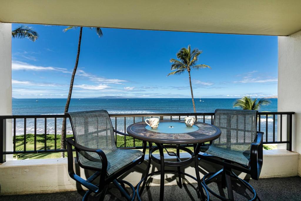 a table and chairs on a balcony with the ocean at SUGAR BEACH RESORT, #319 in Kihei