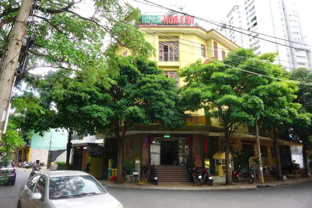 a yellow building with a car parked in front of it at Hoa Sua Hotel in Vung Tau