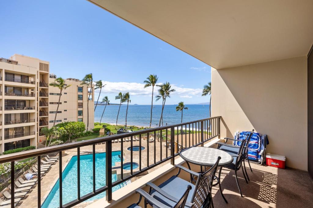 a balcony with a table and chairs and the ocean at SUGAR BEACH RESORT, #409 in Kihei