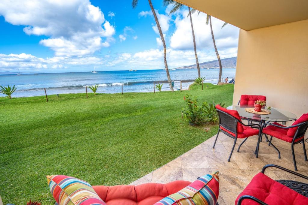 a patio with a table and chairs and the ocean at SUGAR BEACH RESORT, #131 in Kihei