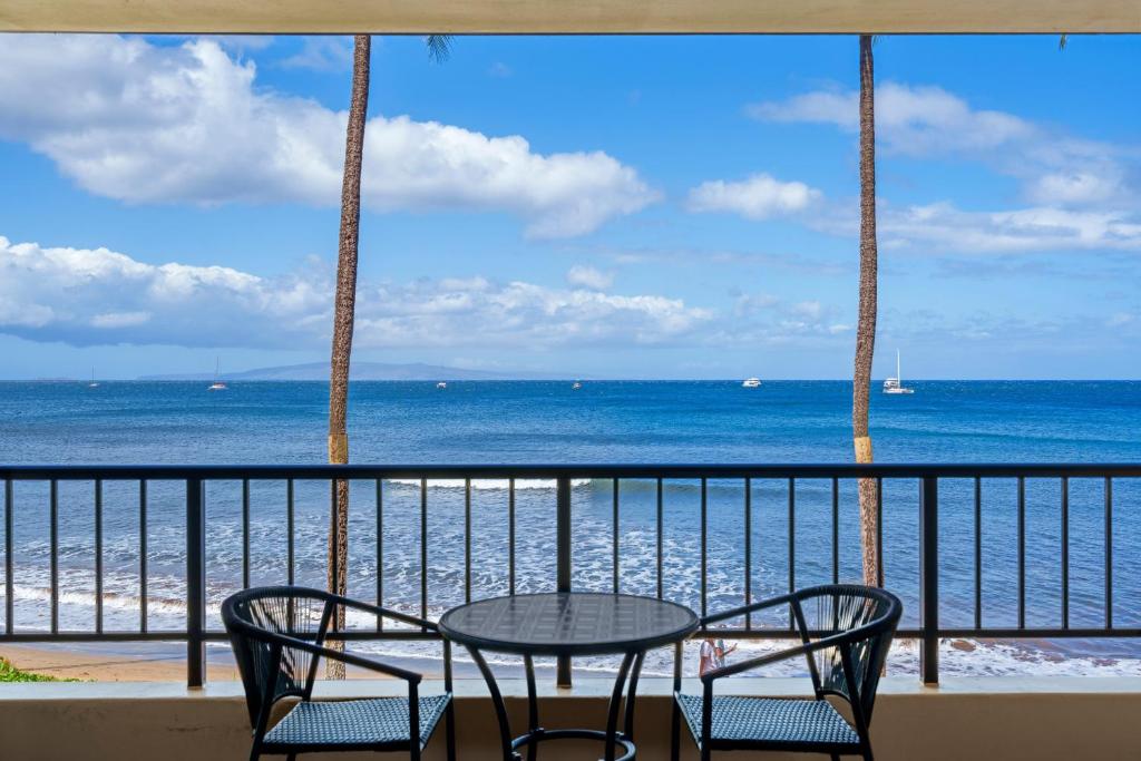 a table and chairs on a balcony overlooking the ocean at SUGAR BEACH RESORT, #235 in Kihei