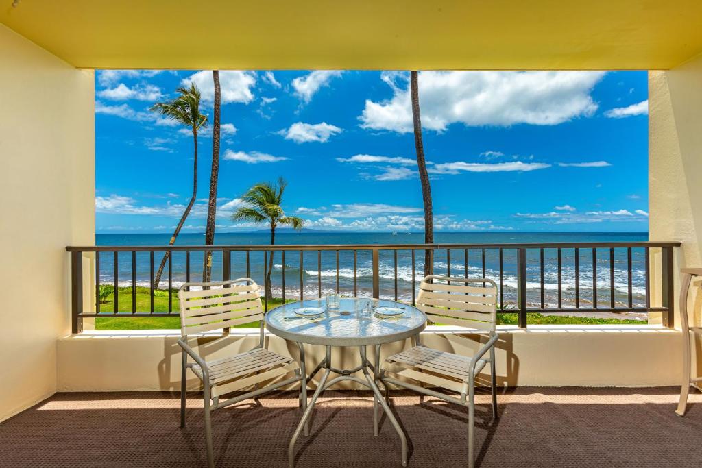 a balcony with a table and chairs and the ocean at SUGAR BEACH RESORT #227 in Kihei