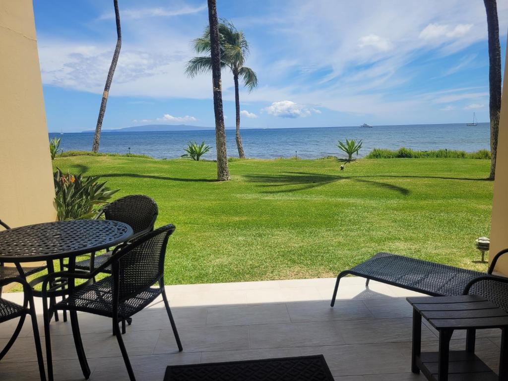 a patio with a table and chairs and the ocean at SUGAR BEACH RESORT #125 in Kihei