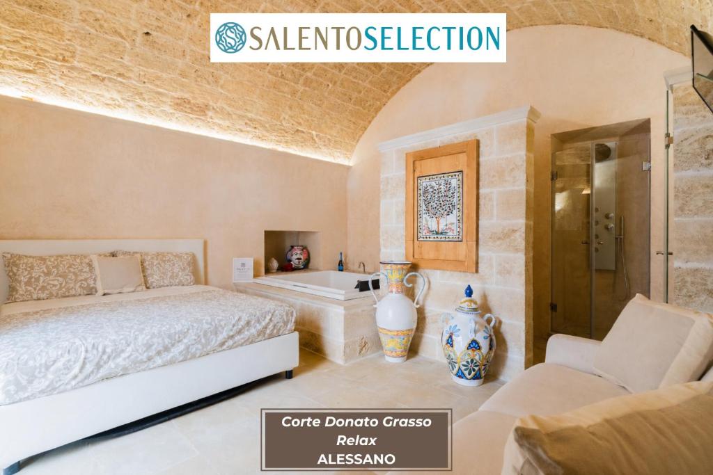 a bedroom with a bed and a tub in a room at Corte Donato Grasso Relax - Salento Selection in Alessano