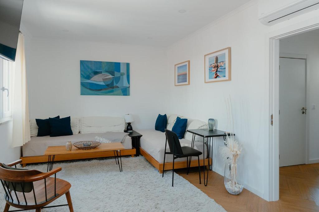 a living room with a couch and a table at Kalumi Aparthotels - Japandi-Style Apartments with Terrace, Pergola, and Portuguese BBQ in Vila Nova de Milfontes