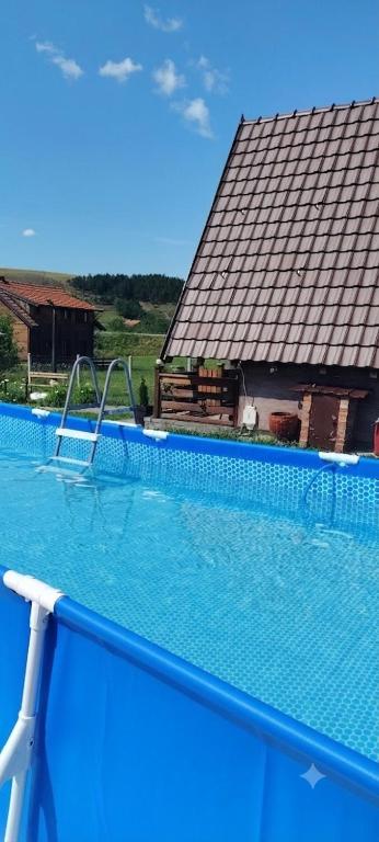 a large swimming pool with a tile roof at Planinska kuca-Jovanovic! in Kremna