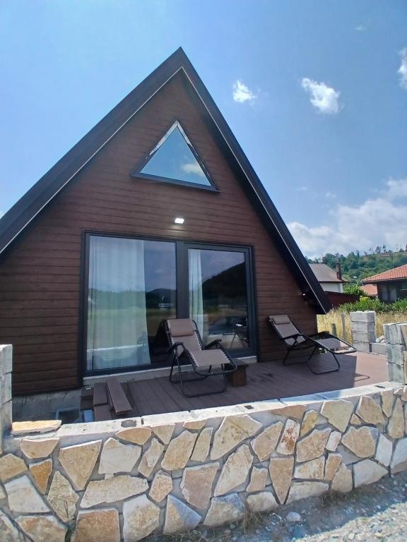 a house with a patio with a stone wall at Chalet Anika in Kolašin