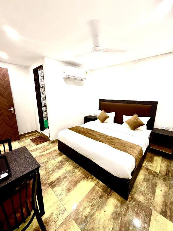 a bedroom with a large bed and a desk at Hotel Vasundhara Villa - Greater Kailash in New Delhi