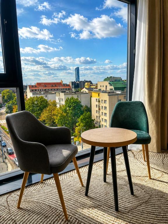 two chairs and a table in front of a window at Tower Hotel Wrocław in Wrocław