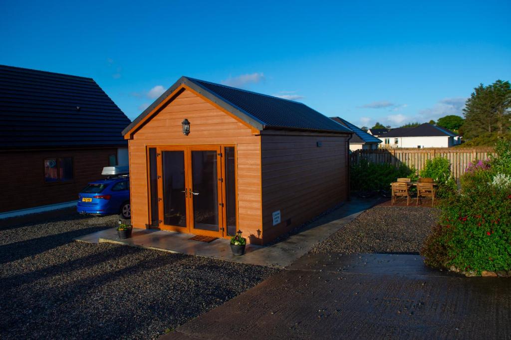 a small shed with glass doors in a yard at Chata in Stornoway