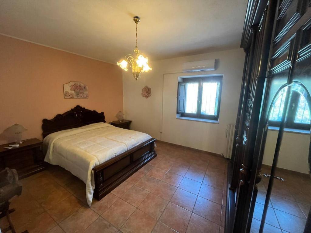 a bedroom with a bed and a window and a chandelier at Villa Maria B&B in Marano Principato