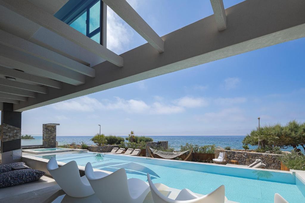 a swimming pool with a view of the ocean at Moonlight Villas Calypso - Sleek Coastal Living by etouri in Koutsourás