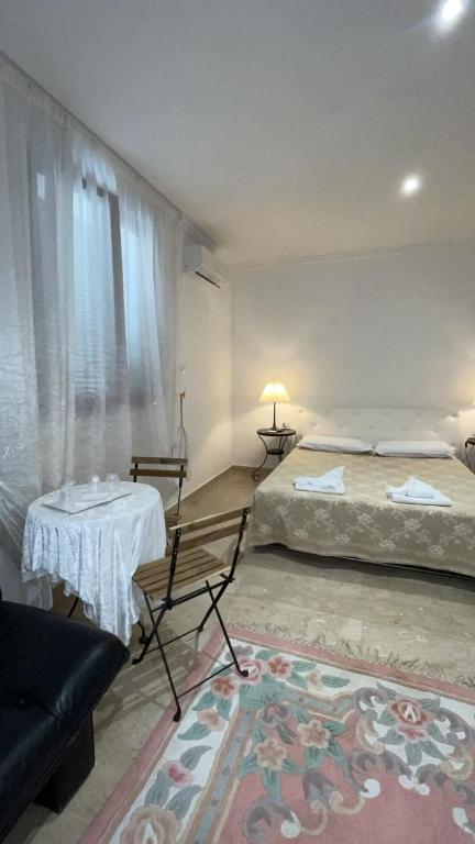 a bedroom with two beds and a table and a couch at casa di malika in Borgo Venusio