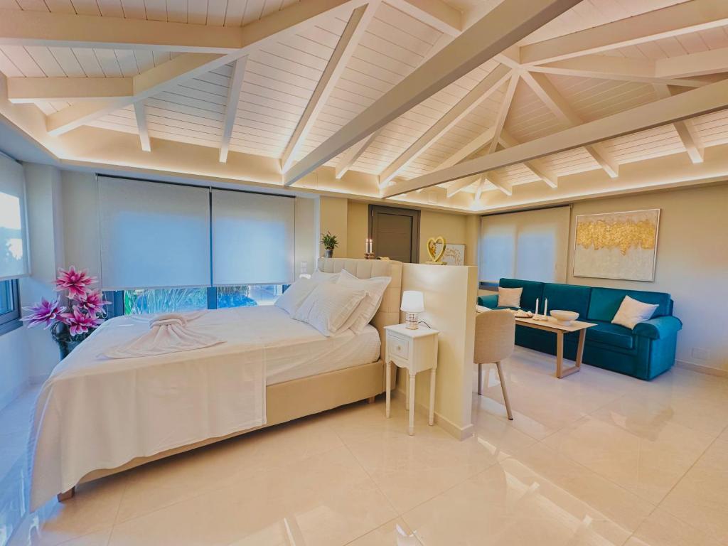 a bedroom with a large bed and a blue couch at Sunset Suite Mytikas in Mytikas