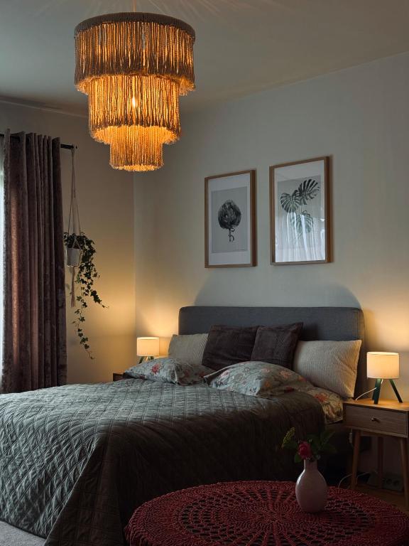 a bedroom with a bed and a chandelier at The Garden room in Ikšķile