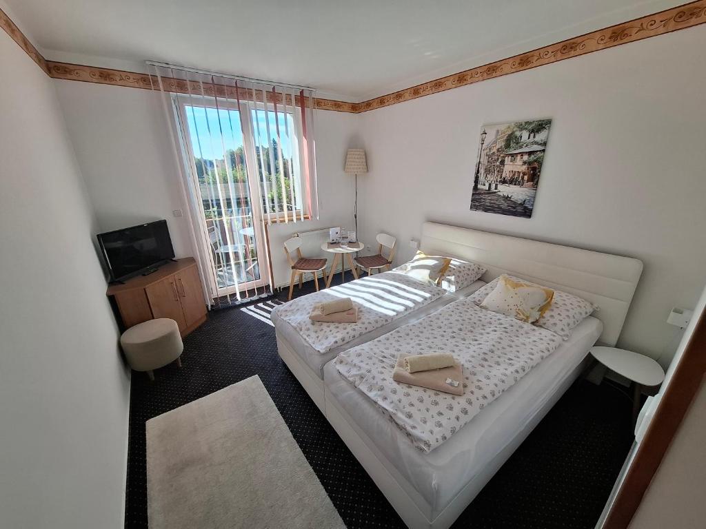 a bedroom with a bed with two towels on it at Pension Three in Františkovy Lázně