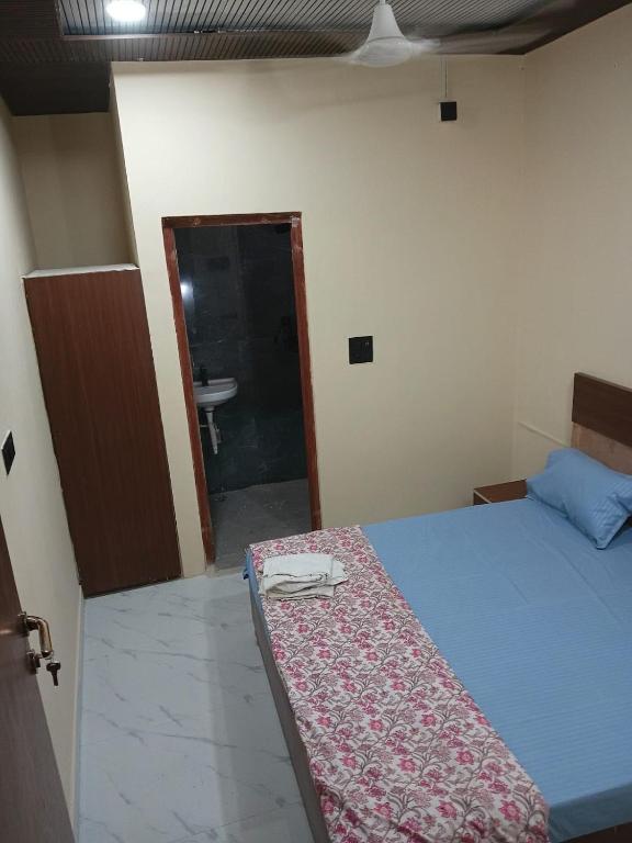 a bedroom with a bed and a bathroom with a sink at Sarovar Home Stay in Vrindāvan